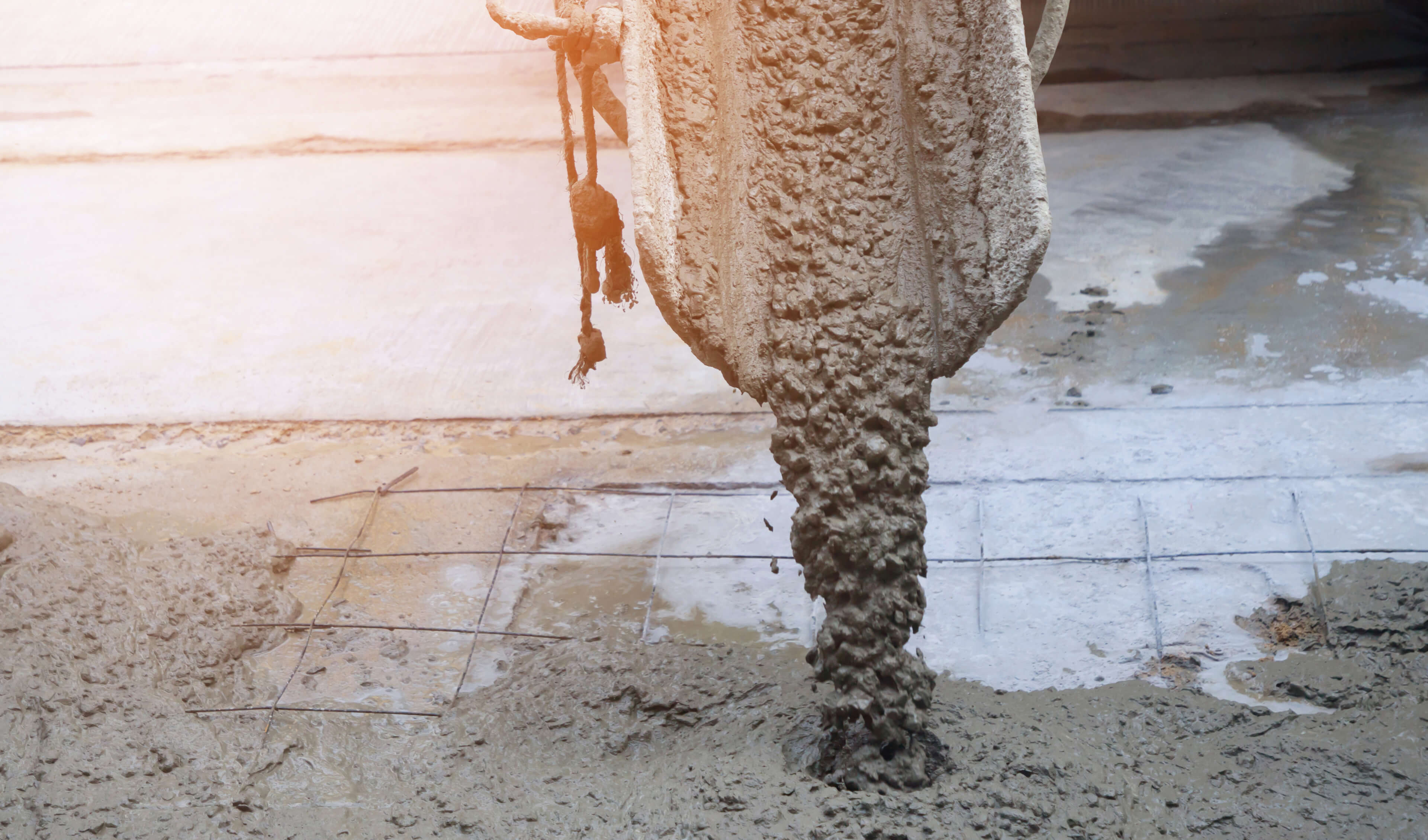 wet concrete coming out of chute onto rebar and sand